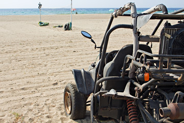 A dune buggy left abandoned on a beach