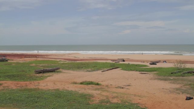 Wide shot waves breaking, waves break on an empty, pristine beach in Muttom, India.