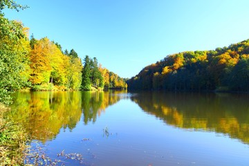 Fototapeta na wymiar Fall landscape on the lake with beautiful colors of forest