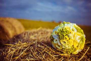 Beautiful green wedding bouquet lies on the heap of hay