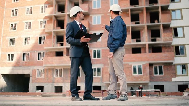 Men discussing the building plan at construction