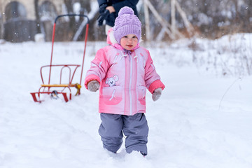 Fototapeta na wymiar Маленький ребенок идет по снегу зимой