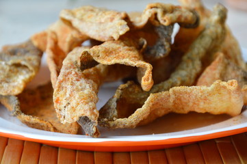 crispy fried fish skin with seasoning on dish