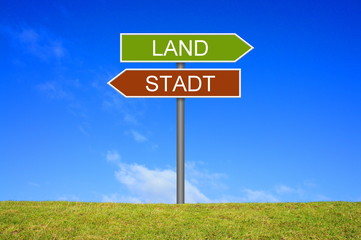 Schild zeigt in Richtung Stadt oder Land