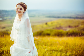 Fototapeta na wymiar Bride closes her eyes standing on the autumn field