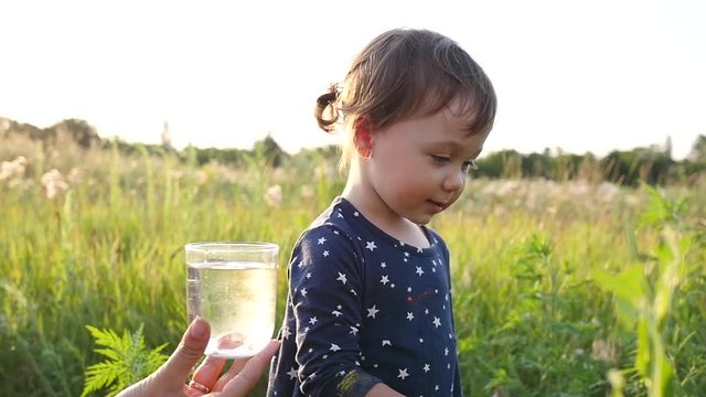 Mother gives child daughter drink clean pure water but she refuses