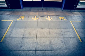 yellow Arrow sign on floor at the sky train station vintage fill