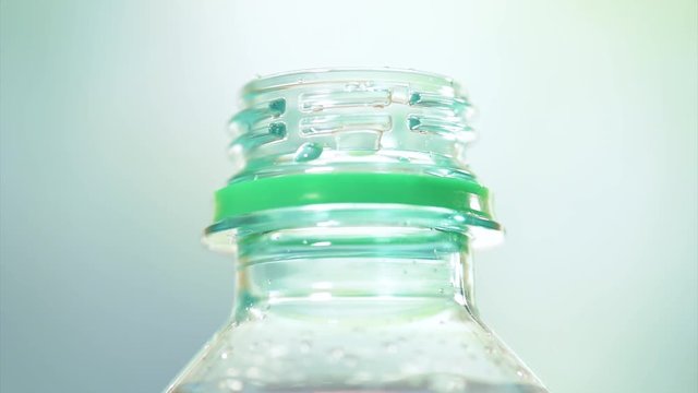 Bottle of fresh mineral water fullHD video. Close-up of plastic bottle cool soda water on abstract light background.