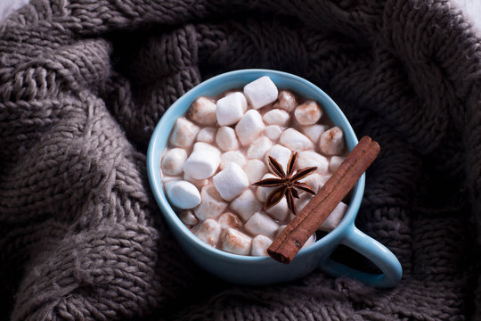 Hot cocoa with marshmallows with spices on the cozy sweater. Coffee, cocoa, chocolate, cinnamon, star anise. Winter Concept, Christmas mood, Cozy Time