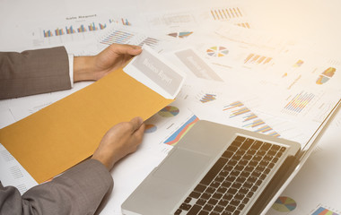 Businessman opening business report document in letter envelope