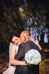 Wedding couple background dry tree and coniferous trees. Kissing man and woman. Middle age newlyweds.