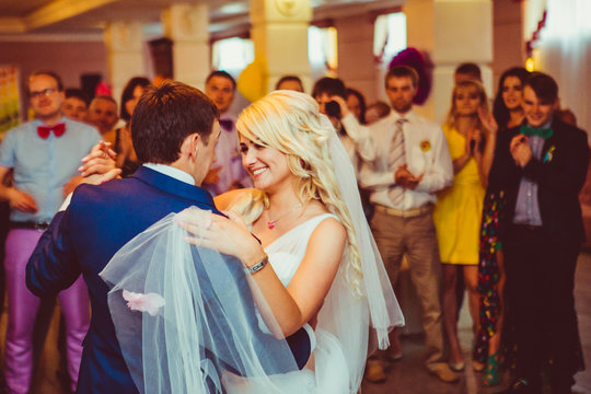 Bride lies her hand over groom's shoulder while dancing in the c