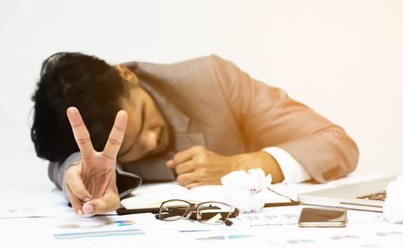 Businessman having two fingers after his jobs acheive, success.