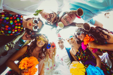 Wedding couple looks down with friends in funny glasses