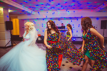 Bride dances with her bridesmaids in spotted dresses