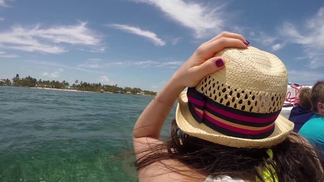 POV on a boat sitting behind a female on a boat cruising the Caribbean Sea, Belize Tourism.