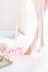 Fototapeta na wymiar wonderful female legs hidden in a transparent white curtain, white light