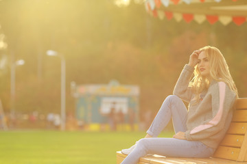 Pretty woman in sitting on the bench in city park.