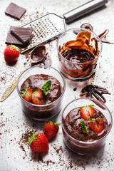 Chocolate mousse with strawberries in glass on rustic table