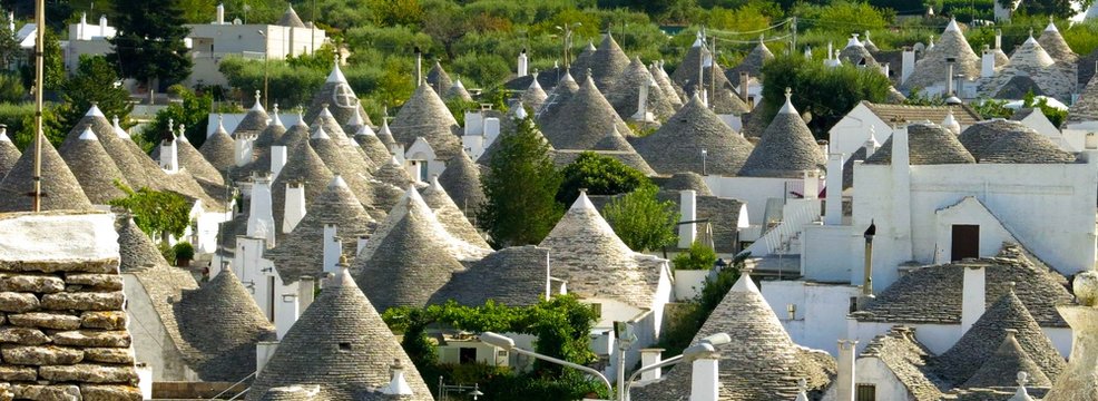 Trulli (plural of trullo) in Alberobello, Italy. View over unusual stone structures with conical rooftops, specific to Itria Valley in Apulia (Puglia). 
