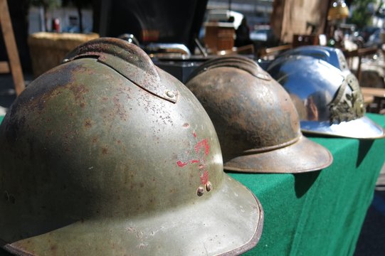 Antique military army helmets at flea market street market in Ostuni, Italy
