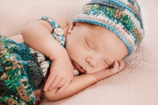 Sleepy little boy in a knitted clothes