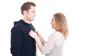 Pretty woman fixing man's autumn casual sweater