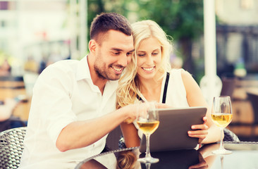 happy couple with tablet pc at restaurant lounge
