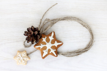 decorating for the winter holidays/ pine cone and ginger cookies on a light wooden surface 