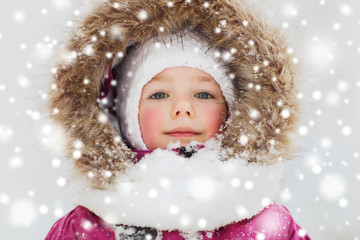 face of happy little kid or girl in winter clothes