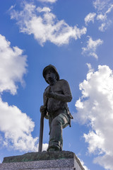 Fototapeta premium Firefighter statue with blue sky and clouds in the background