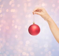 close up of woman in sweater with christmas ball