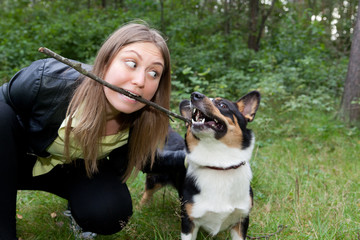 Naklejka na ściany i meble Young woman playing with the dog Welsh Corgi Cardigan