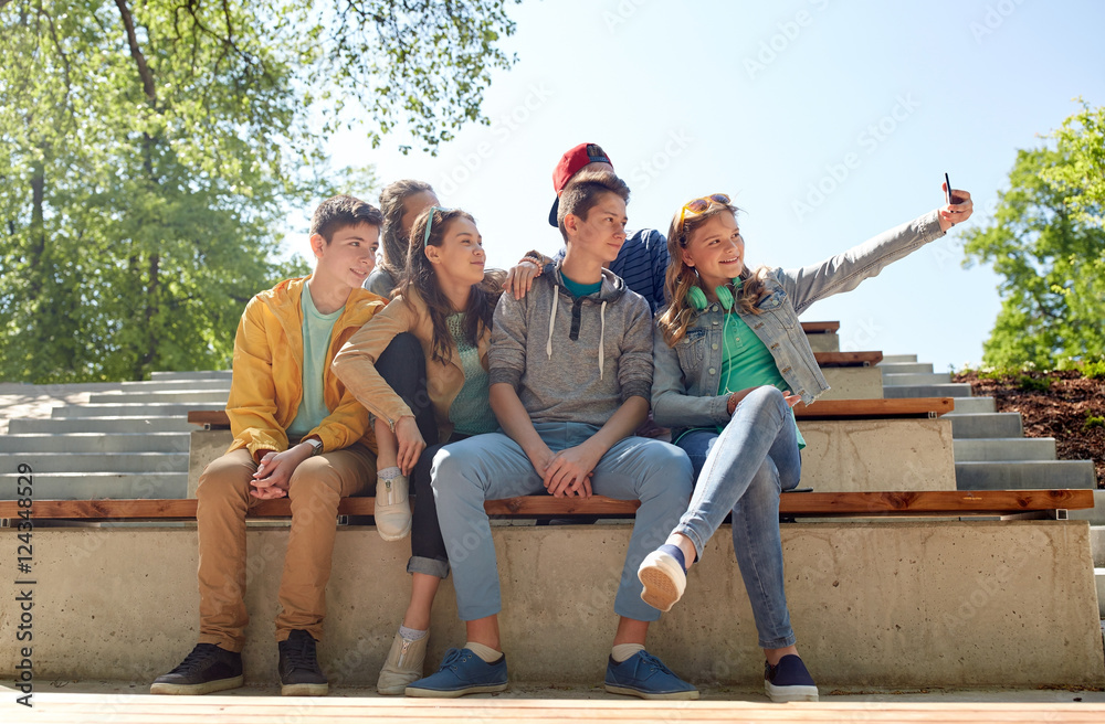 Wall mural happy teenage students taking selfie by smartphone