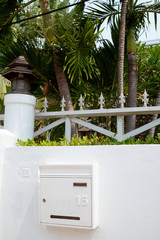 House mailbox mounted on a white villa fence