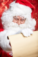 Checking his special list. Traditional Santa Claus sitting at hi