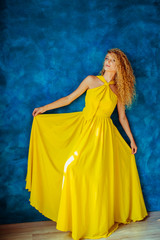 woman in a yellow dress looks at photographer