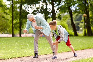 grandfather and grandson racing at summer park