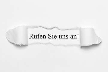 Fototapeta premium Rufen Sie uns an! auf weißen gerissenen Papier