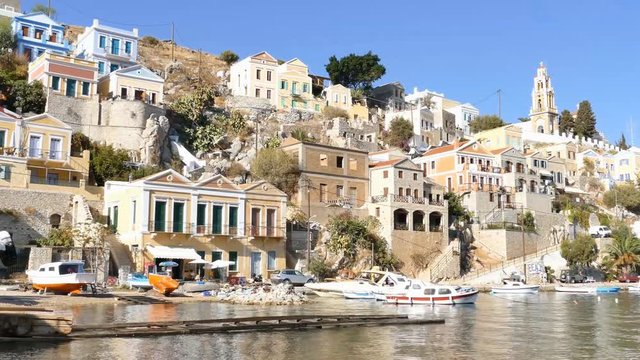 Symi island - Colorful houses and small boat, pan right footage at the heart of the village