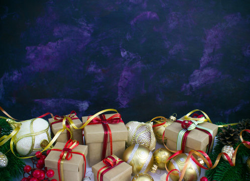 Christmas or New Year background: fur-tree, branches, gifts, colored glass balls, decoration and cones on a dark background