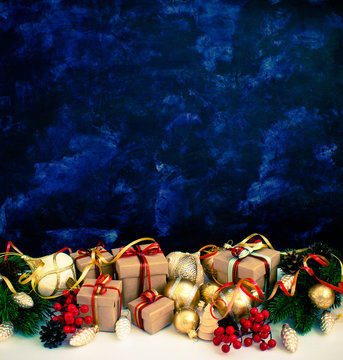 Christmas or New Year background: fur-tree, branches, gifts, colored glass balls, decoration and cones on a dark background