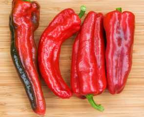 Red fresh pepper fruits on wooden Board, top view
