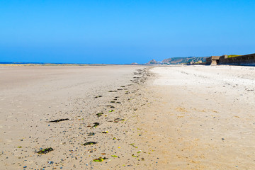 A line of debris left by at low tide on a Jersey beach.