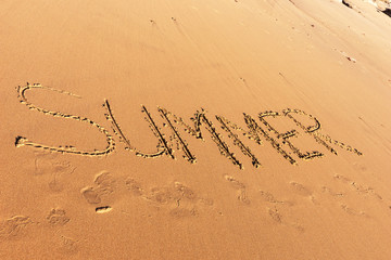 Summer word written in the sandy beach