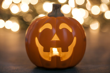 Glowing halloween pumpkin against bright bokeh lights