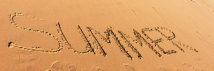 Summer word written in the sandy beach