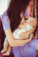 Mother brestfeeding near the window