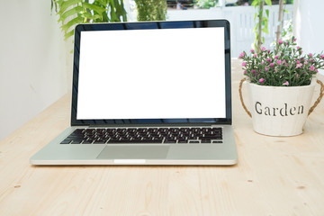 Fototapeta premium Office table with blank screen on laptop and rose flower on pot