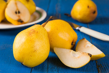 Fresh ripe organic yello pears on blue rustic wooden table, natural background, diet food.